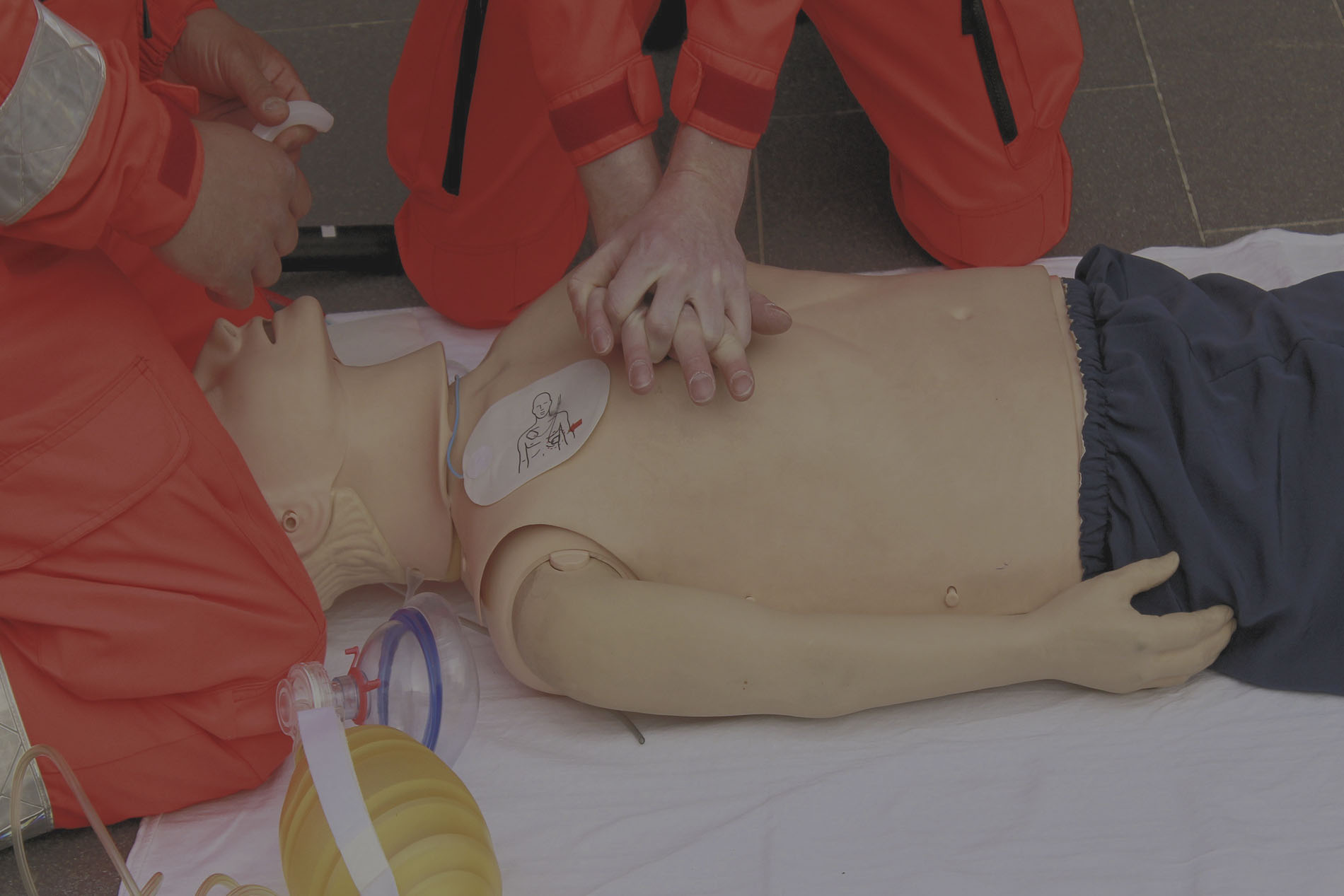 pessoas fazendo massagem cardíaca em um boneco de simulação